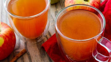 homemade apple cider in mugs with cinnamon and apples