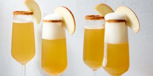 apple cider mimosas with a cinnamon rim and apple slices