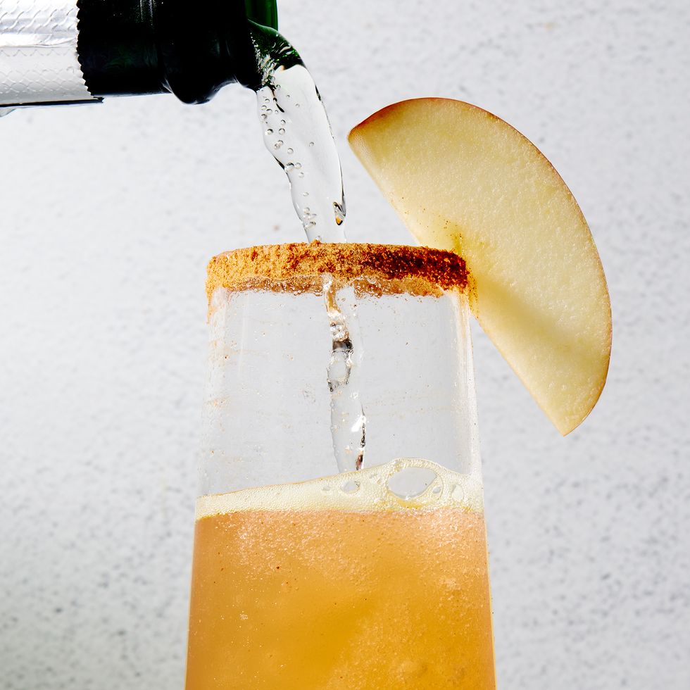 apple cider mimosas with a cinnamon rim and apple slices