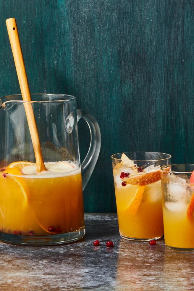 a pitcher of apple cider sangria with two glasses on the side