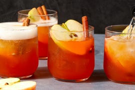 apple cider spritzes garnished with apples and cinnamon sticks