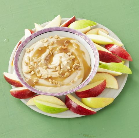 caramel apple dip with apple slices green background