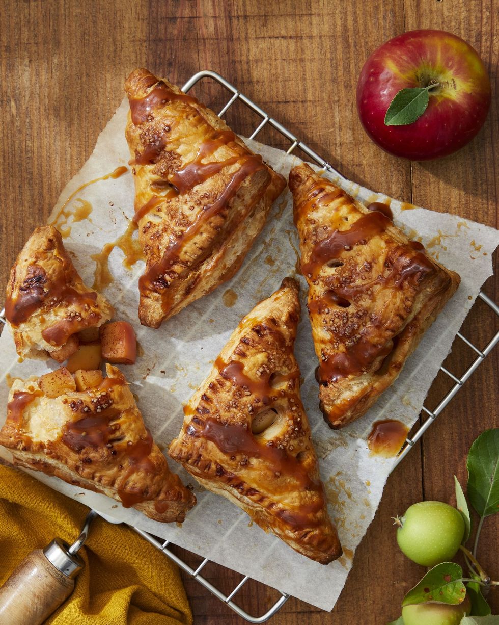 caramel apple turnovers on a parchment lined rack and drizzled with caramel