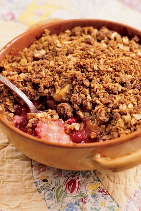cranberry apple crisp  in a baking dish with a spoon for serving