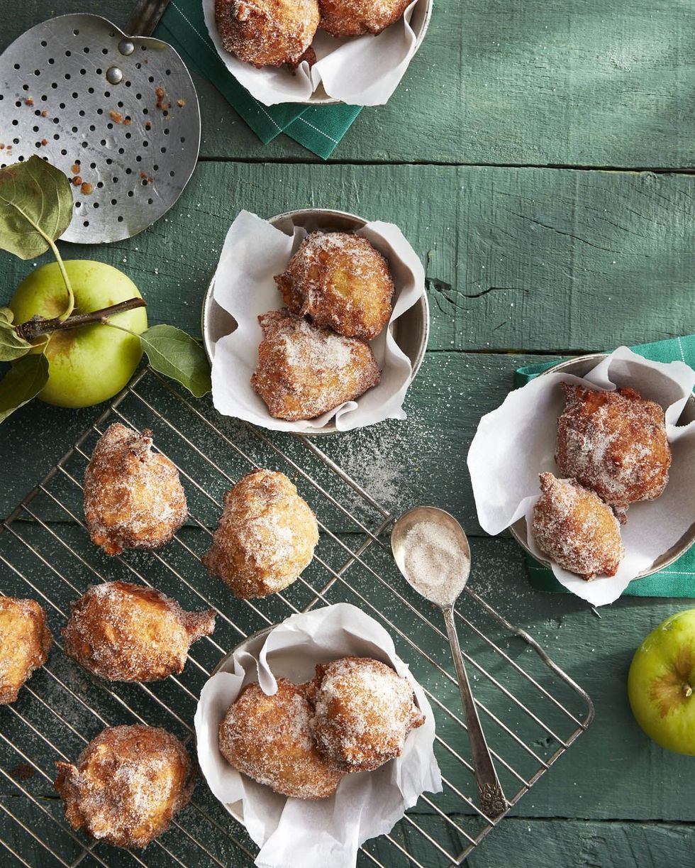 pie spiced apple fritters on a wire rack and some in parchment lined bowls