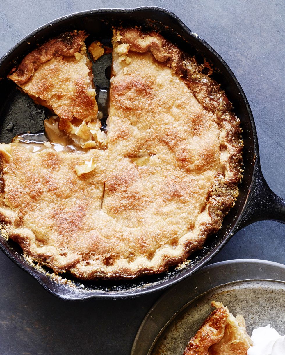 apple pie baked in a cast iron skillet with a slice cut out