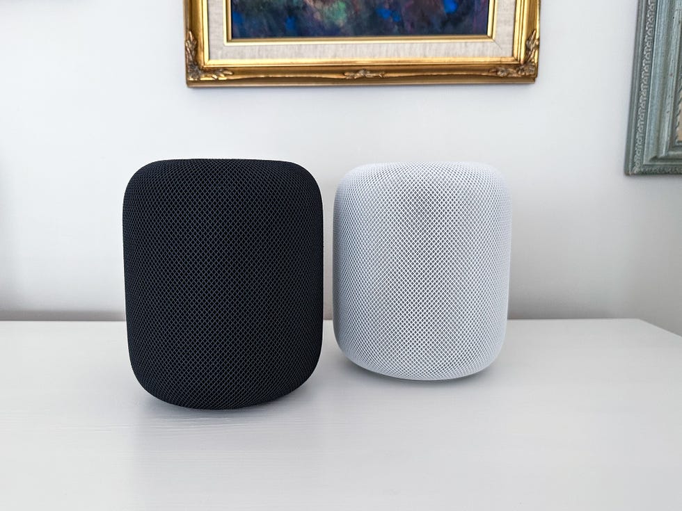 apple homepod black and white model sitting next to each other on a counter
