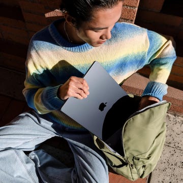 a person pulling a laptop out of a rucksack