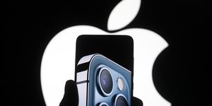 imagen de un móvil iphone 12 pro en primer plano con el logo de la manzana de apple al fondo