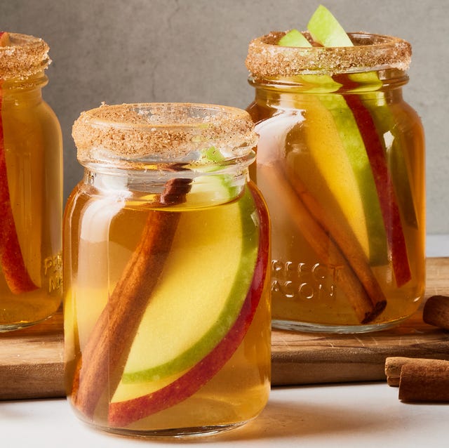 Apple Pie Bourbon Shots apple pie bourbon shots with apple slices and cinnamon sticks in little mason jars