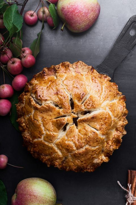 Apple pie in cast iron skillet on rustic table