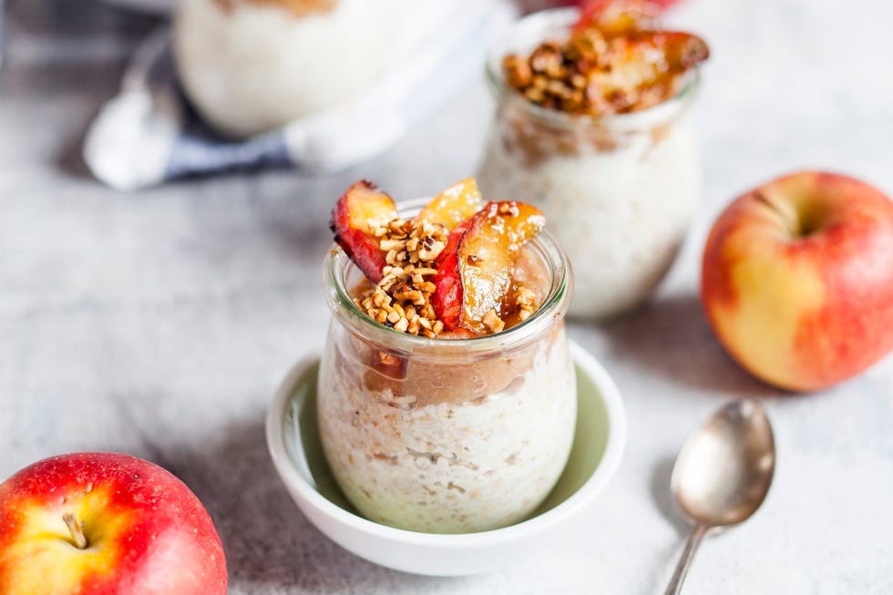 overnight oats in a glass jar topped with caramelized apples and hazelnuts