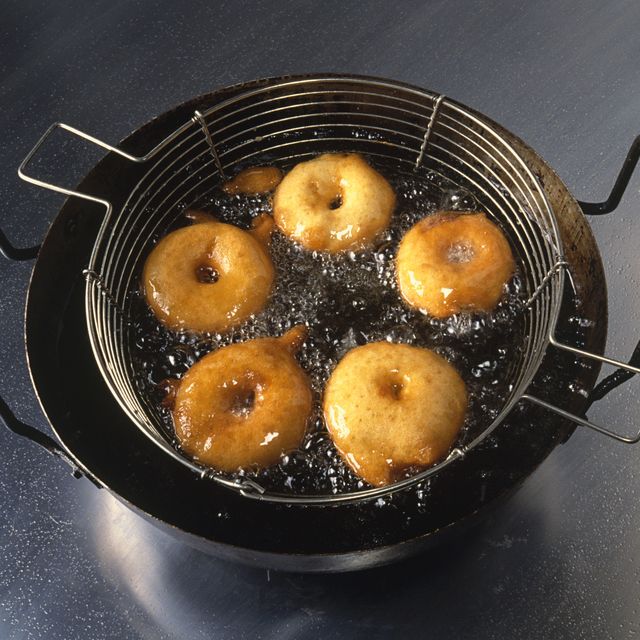 Apple rings coated in batter deep-frying in pan