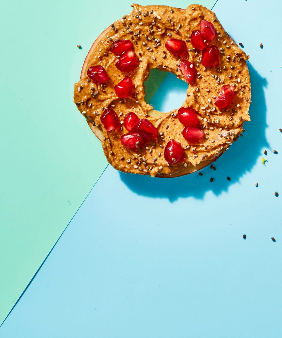 apple slice with almond butter and pomegranate seeds on top