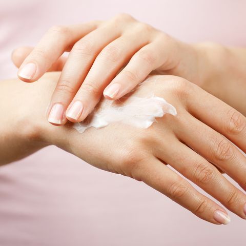 feminine hands applying hand cream