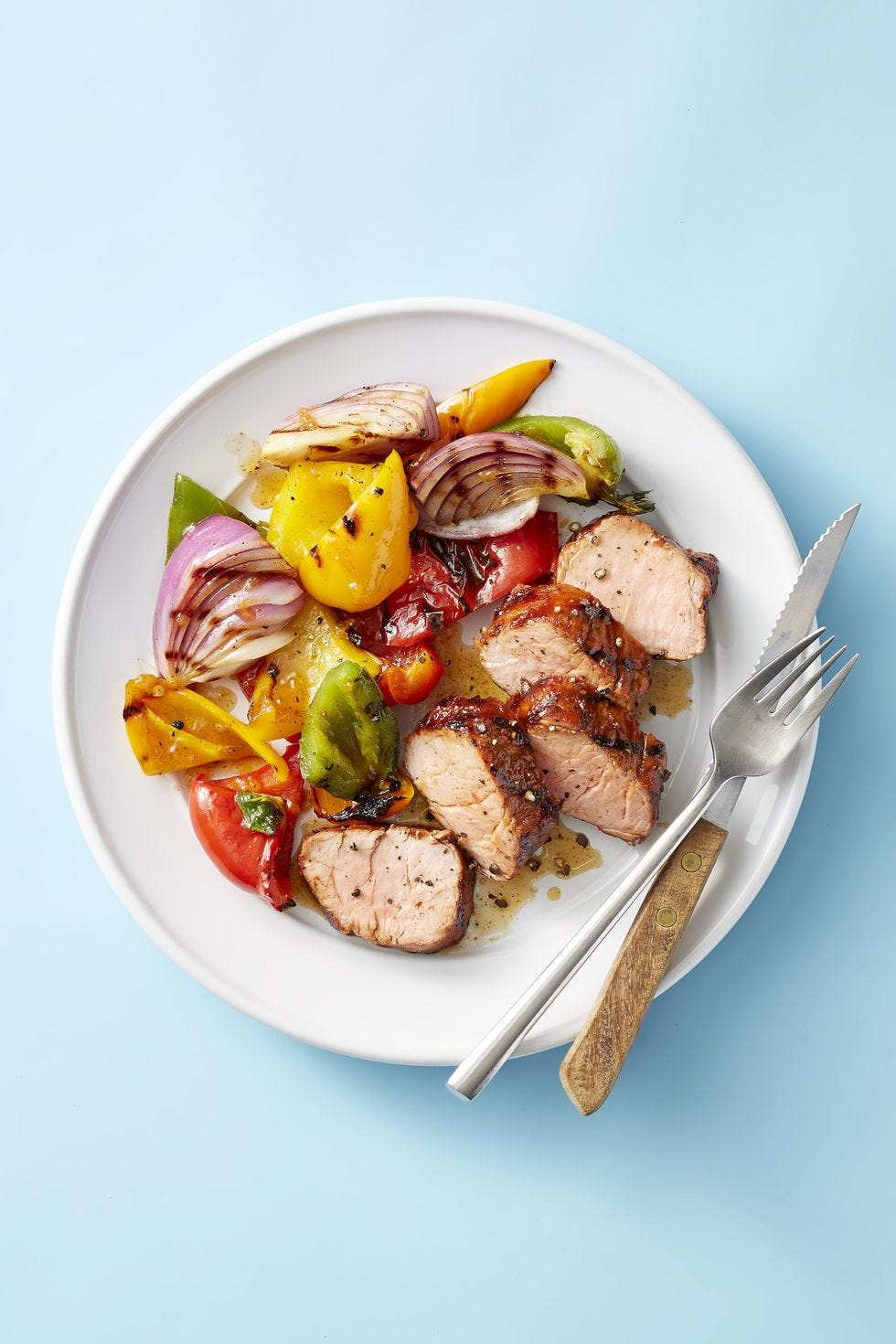 apricot grilled pork tenderloin and peppers on a white plate
