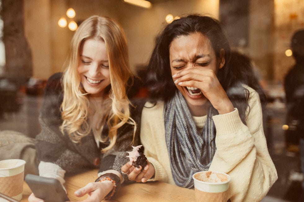 girlfriends using smartphone in coffeeshop