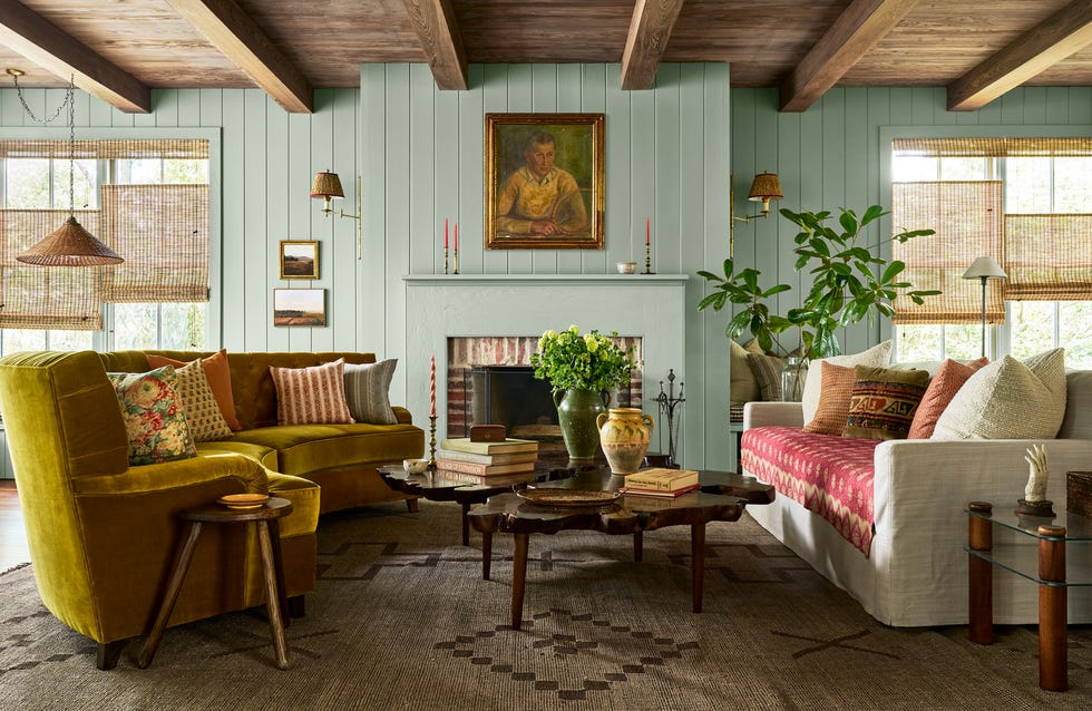 family room with blueish gray walls, a big fireplace, bright green velvet curved sofa