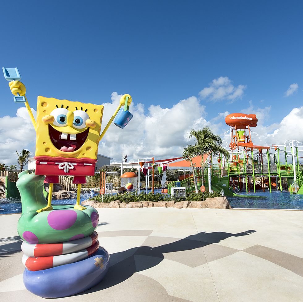 a statue of spongebob stands in front of the pool area at the nickelodeon hotel and resorts a good housekeeping pick for best all inclusive family resorts