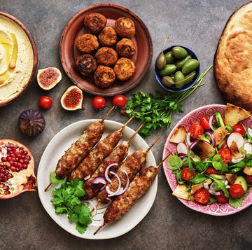 arabic and middle eastern dinner table hummus, tabbouleh salad, fattoush salad, pita, meat kebab, falafel, baklava, pomegranate set of arabian dishestop view, flat lay