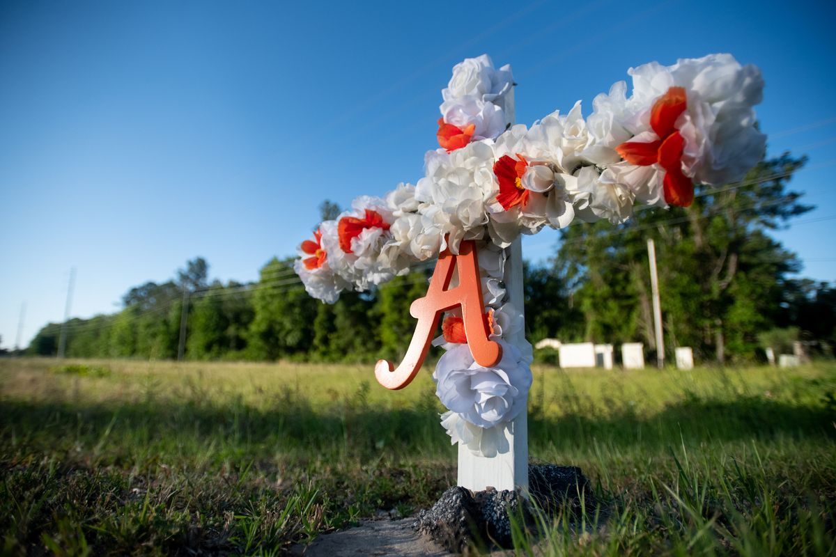 brunswick, ga   may 07 a cross with flowers and a letter a sits at the entrance to the satilla shores neighborhood where ahmaud arbery was shot and killed  may 7, 2020 in brunswick, georgia arbery was shot during  a confrontation with an armed father and son on feb 23 photo by sean rayfordgetty images