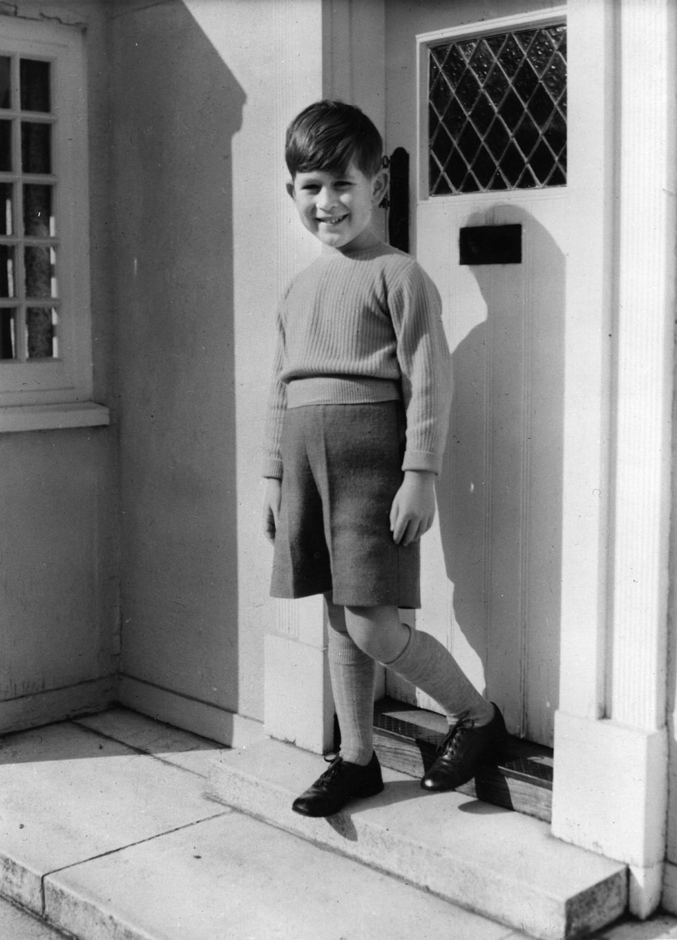 el príncipe carlos de pequeño en la puerta de una casa en ua foto en blanco y negro