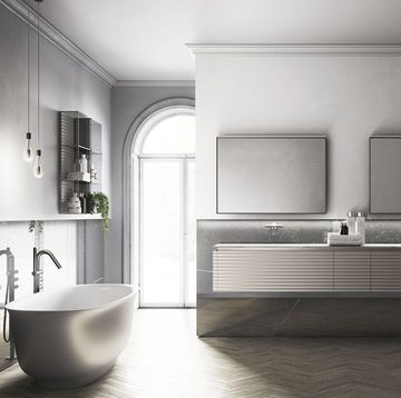 Grey and white bathroom with freestanding bath, twin sink vanity and herringbone floor