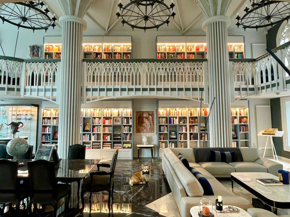 elegant reading room with bookshelves a dining area and a pet dog elegant reading room with bookshelves a dining area and a pet dog