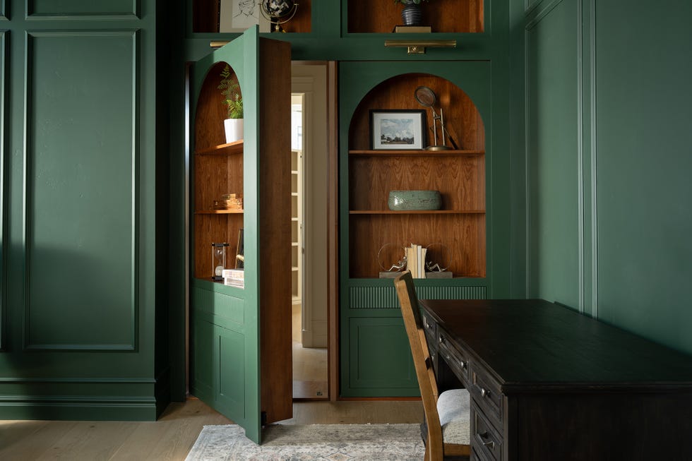 a modern workspace with a desk and green cabinetry