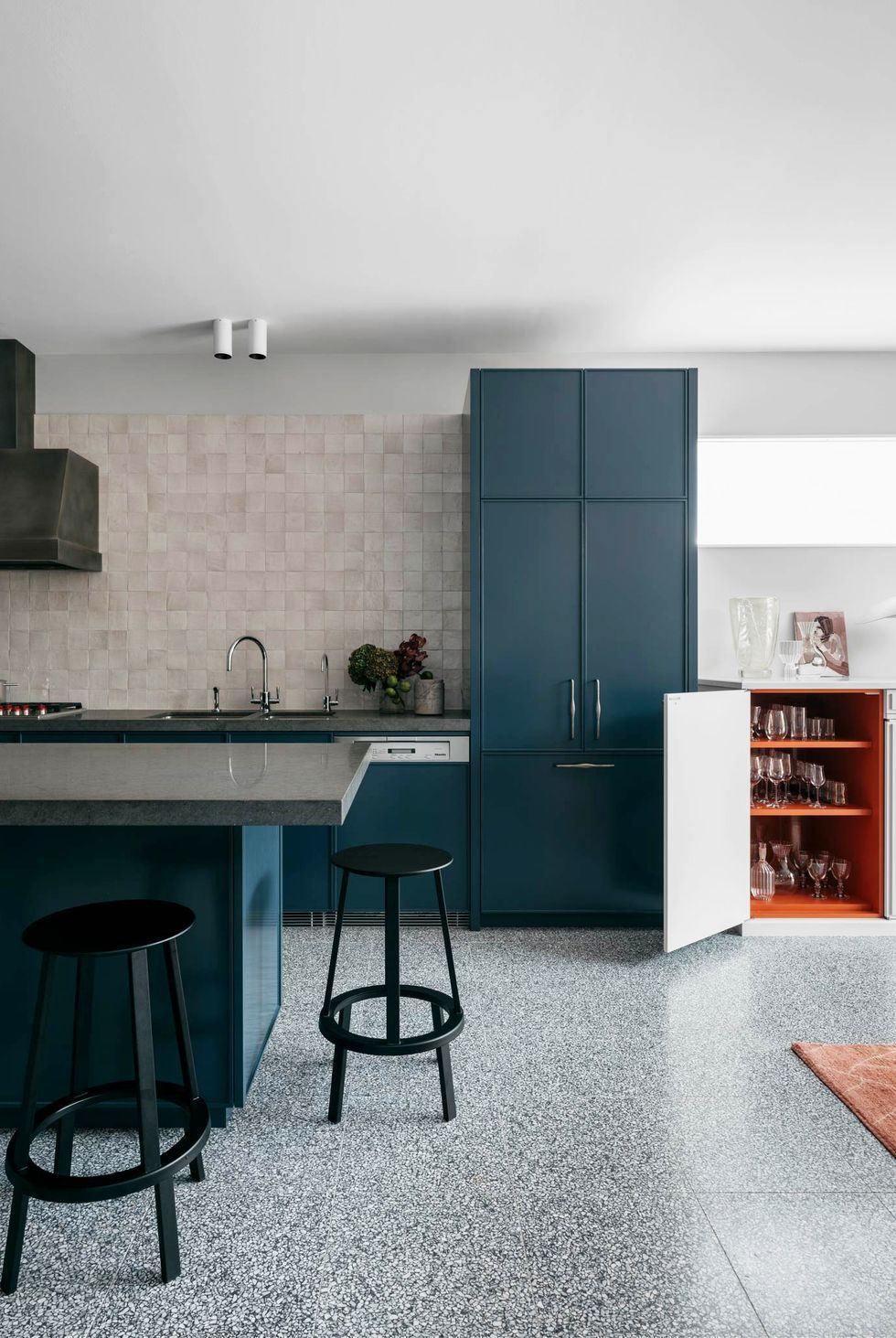 modern navy blue kitchen with orange interior cabinets