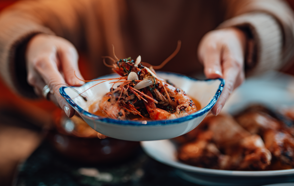 woman hands a plate of food