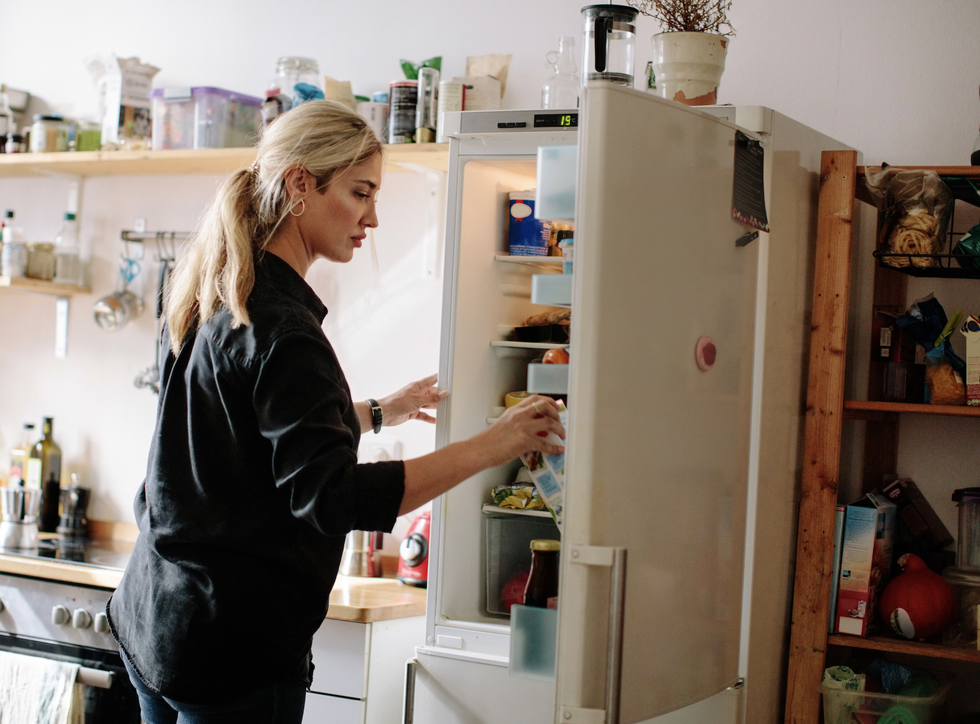 woman opens fridge