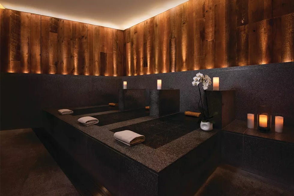 spa relaxation area with stone benches and soft lighting spa relaxation area with stone benches and soft lighting