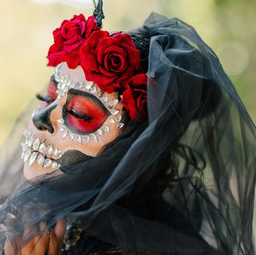 a person wearing a day of the dead mask with a flower crown