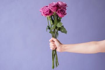 arm of caucasian woman holding bouquet of roses