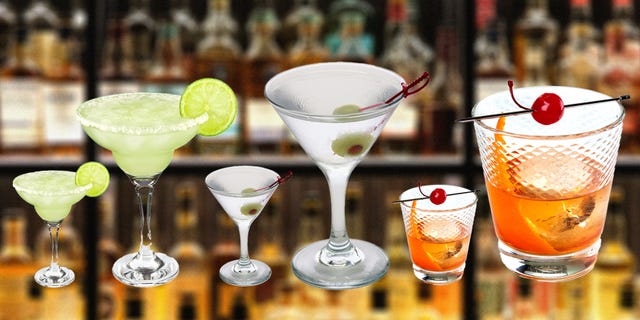 a variety of cocktails displayed against a blurred bar background