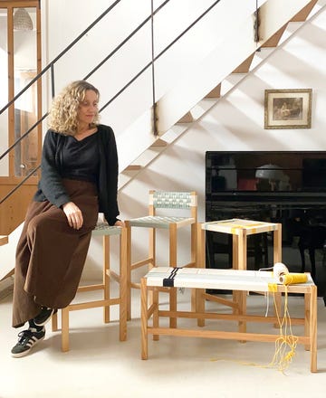 ainhoa perez urdangarin, artesana de sillas con sus piezas junto a una escalera