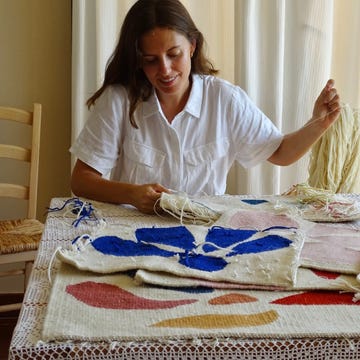 Ines Prat tejiendo ines prat tejiendo tapices de colores azules y rosas sobre una mesa