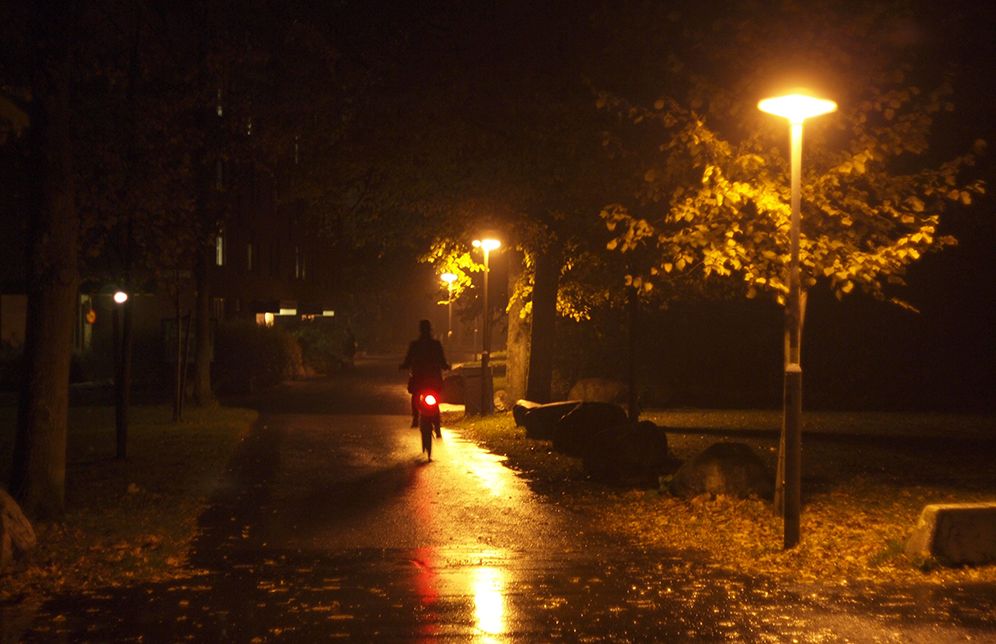 Cyclist riding alone on the street in the rain with a bike light