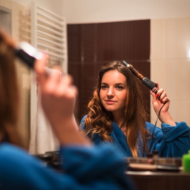 woman using curling iron in hair