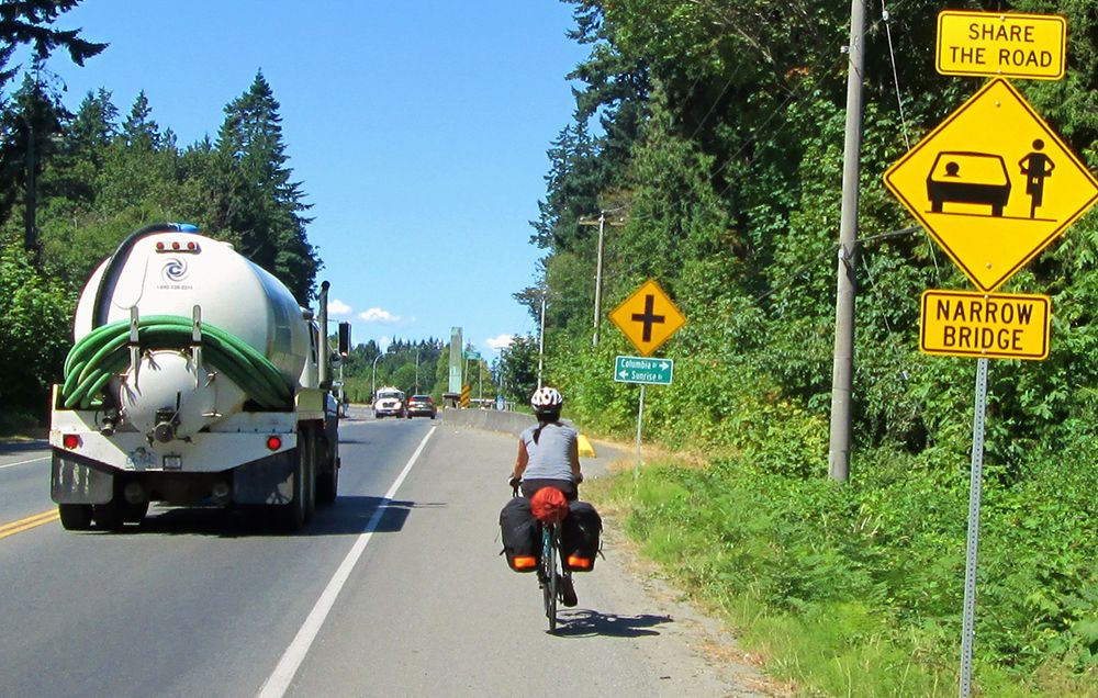 A cyclist near a Share the Road sign. 