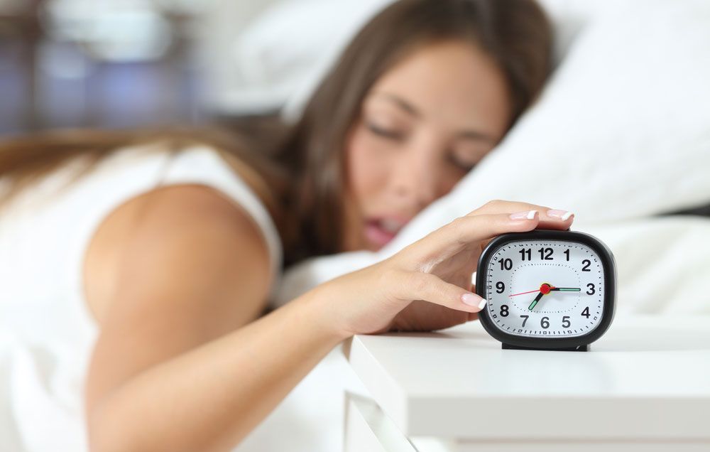 woman hitting alarm clock
