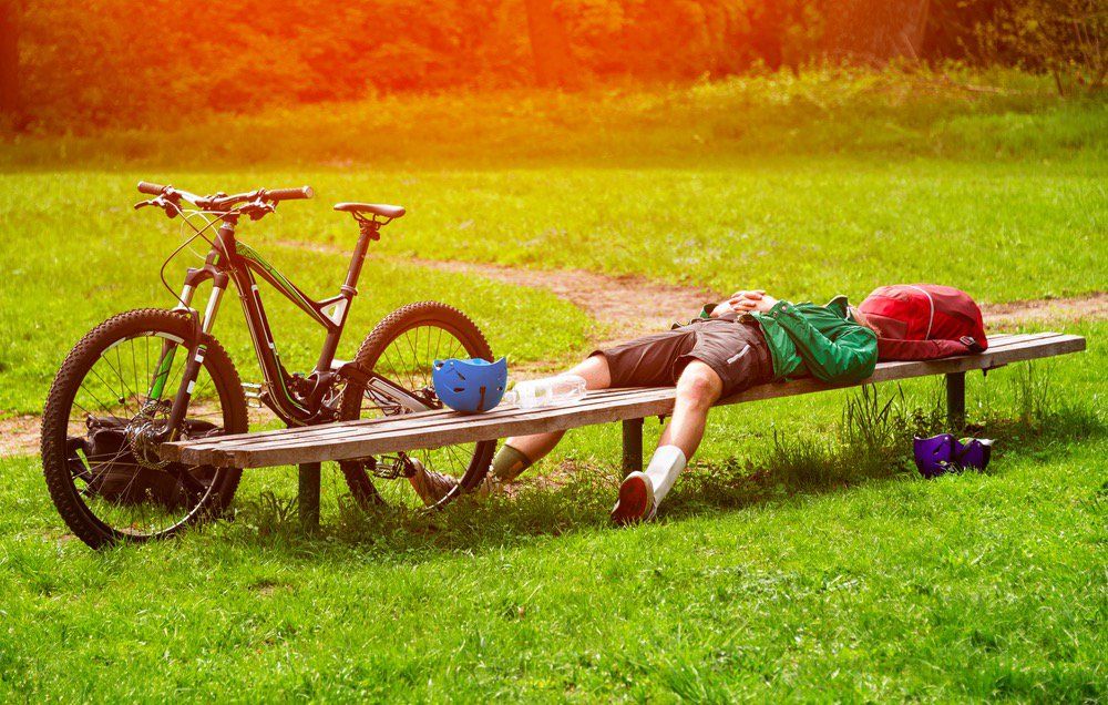 A cyclist resting on a bench. 