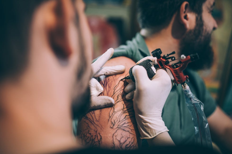 artist tattooing a man in studio