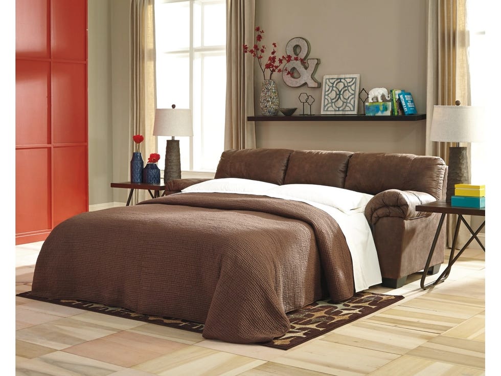 a brown leather ashley furniture bladen full sleeper sofa with the mattress pulled out and a brown quilt on top, good housekeeping's best sleeper sofas