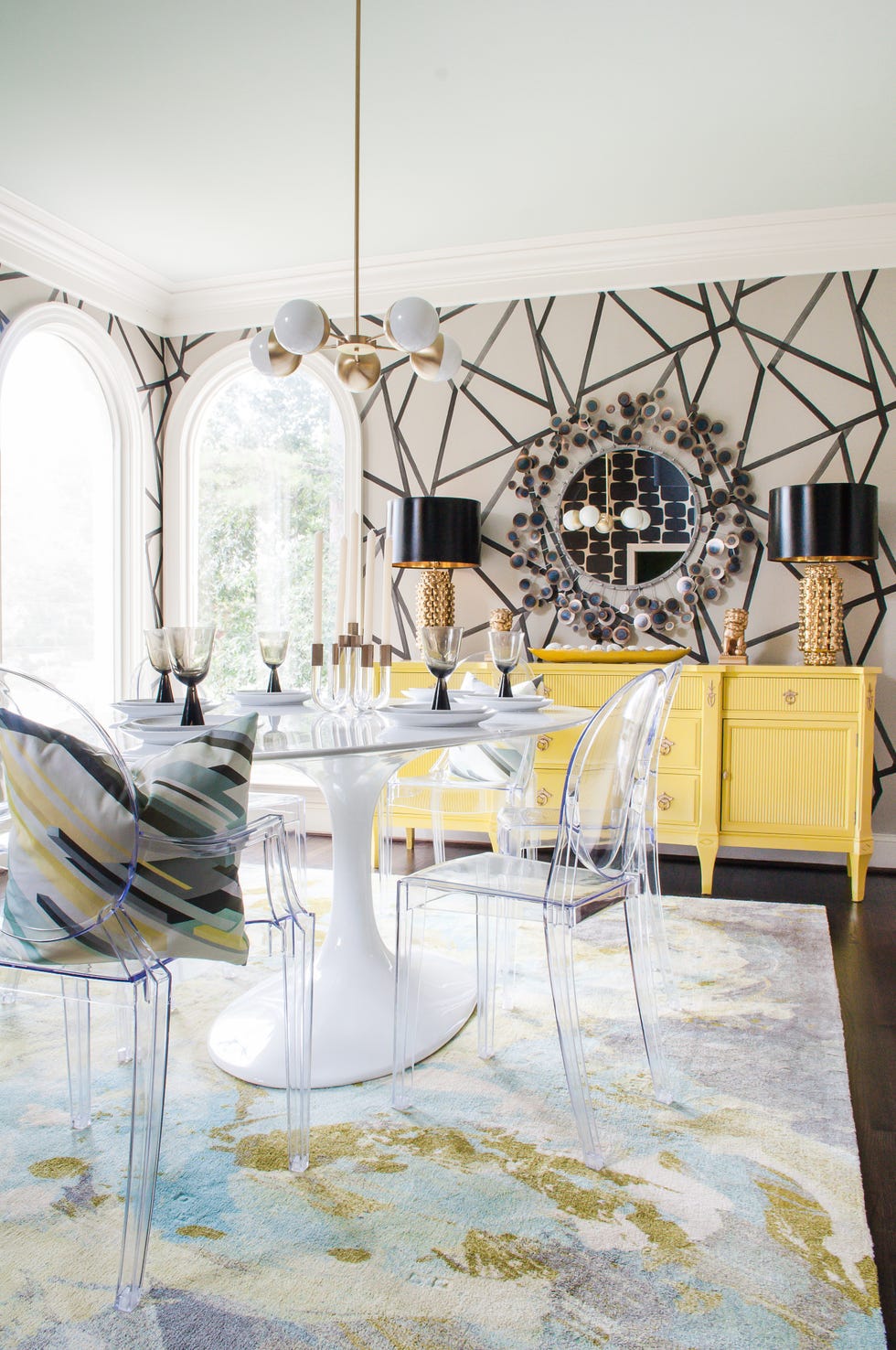 dining room with patterned wallpaper and lucite chairs