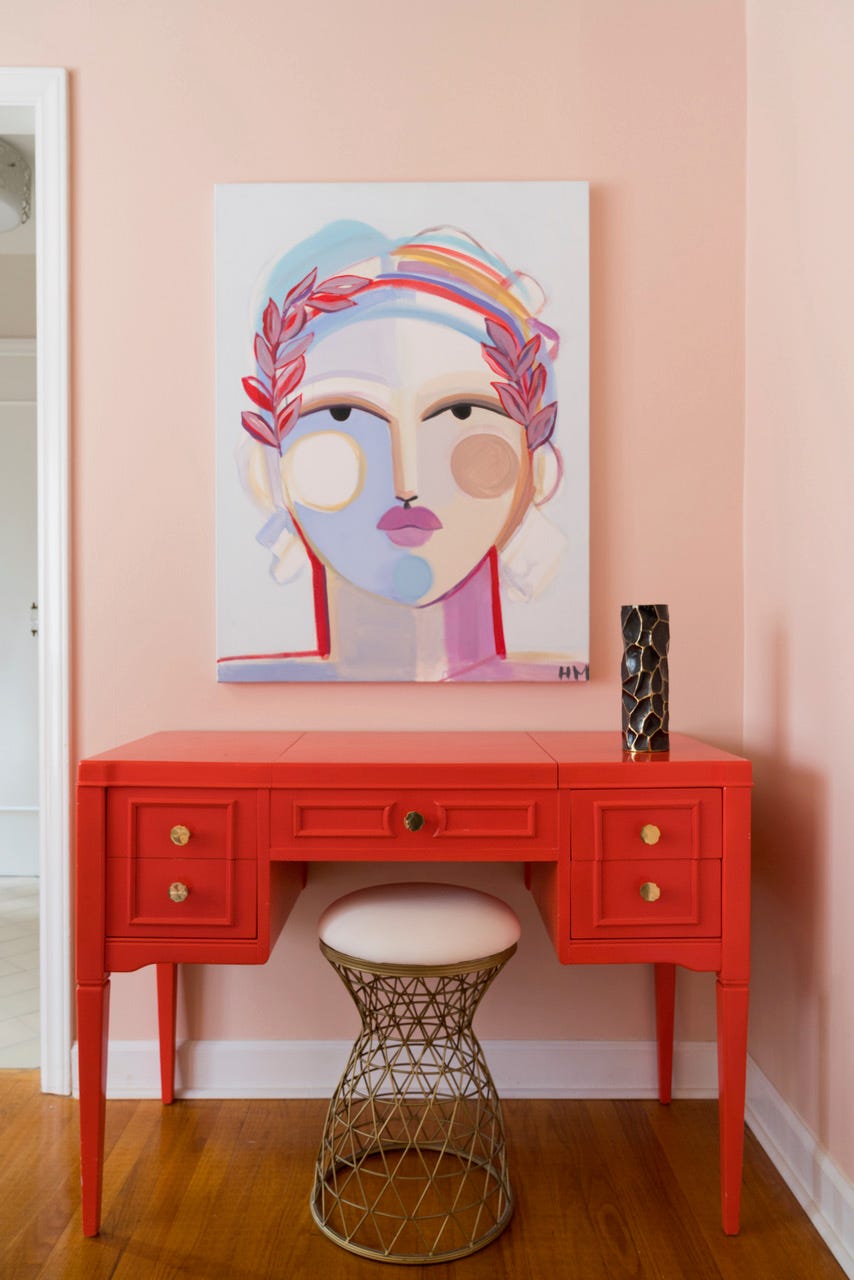 room with peach walls and red desk