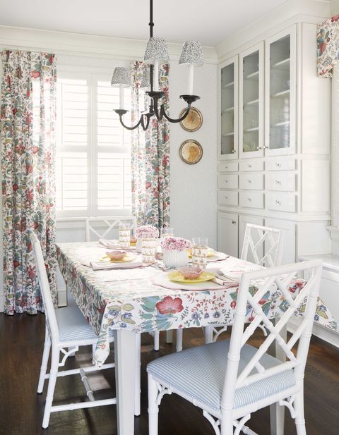 breakfast room, white dining chairs, white and blue stripped chair cushions, white storage, floral curtains and table top