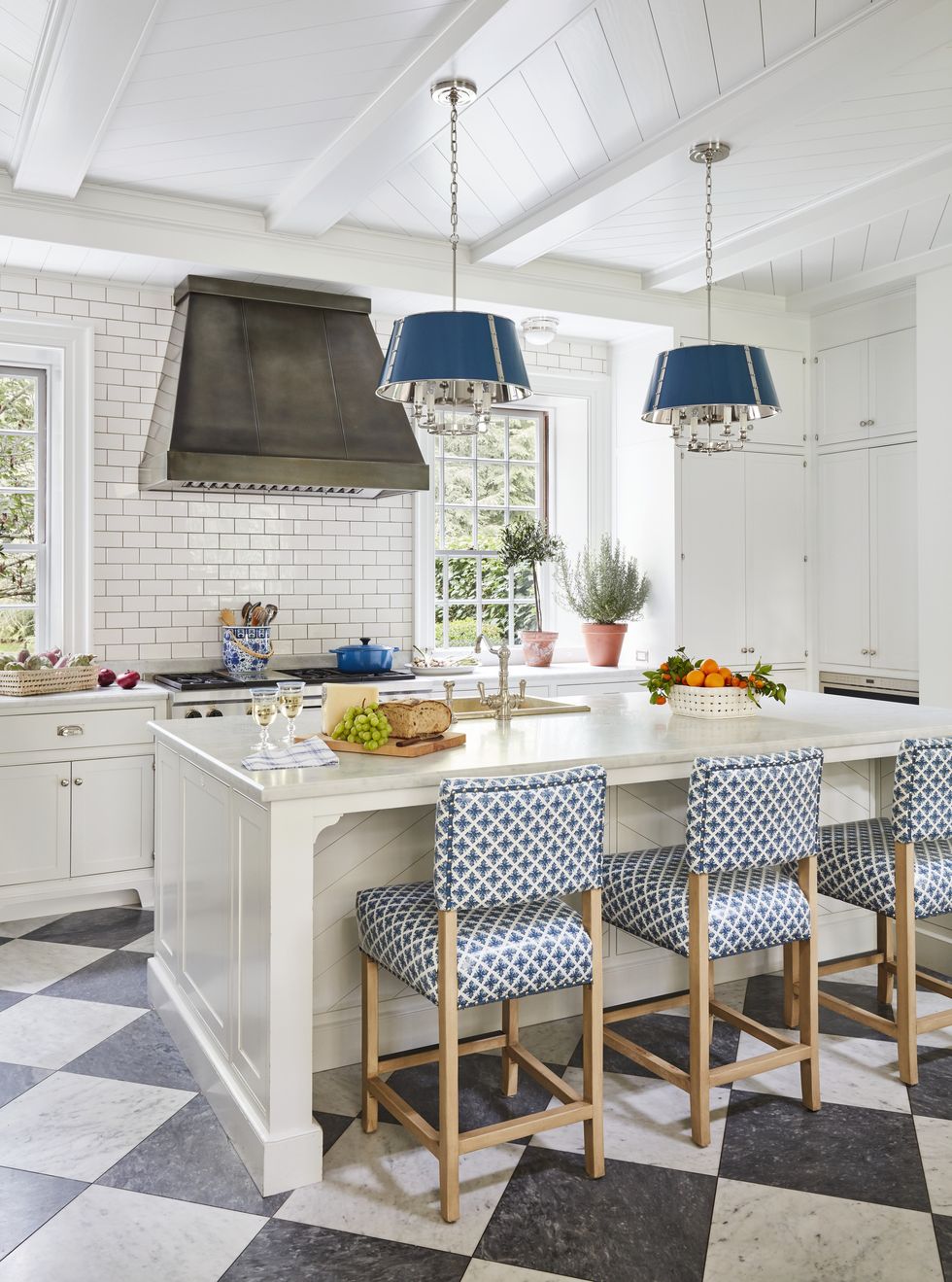 in a kitchen a duo of disarming patterns enlivens warm shades of white in counters and cabinetry and subway tile
