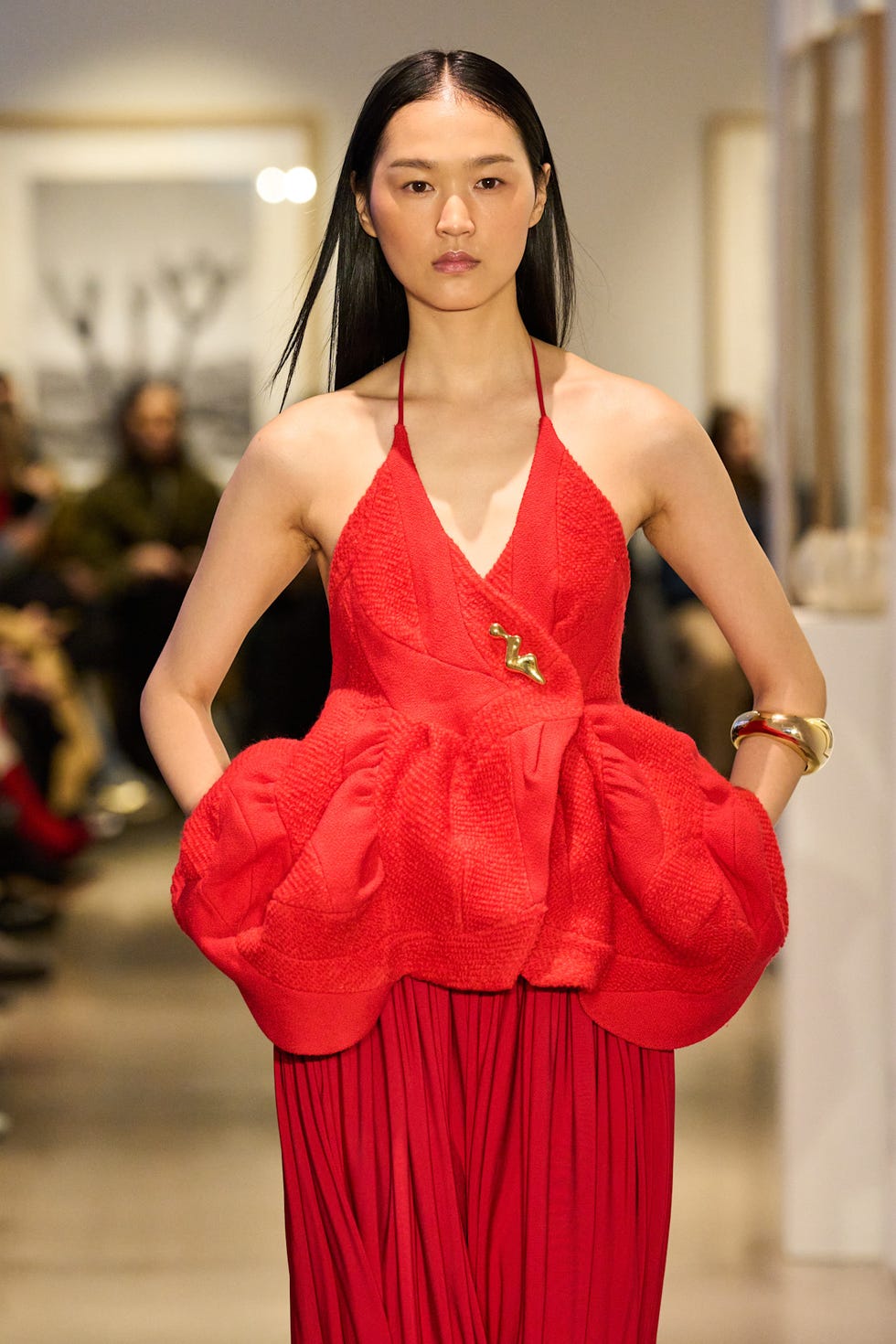 Model showcasing a bold red outfit on a runway